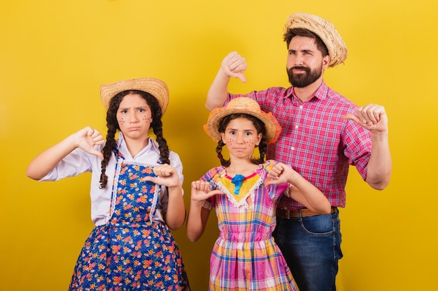 Vader en dochters dragen typische kleding voor het Festa Junina Duim omlaag afkeuring afkeuring Voor het Arraia-feest