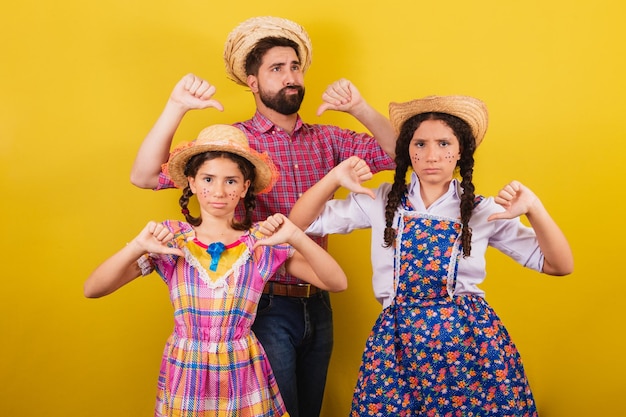 Vader en dochters dragen typische kleding voor het Festa Junina Duim omlaag afkeuring afkeuring Voor het Arraia-feest