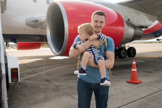 Vader en kind die op vliegtuig in luchthaven inschepen