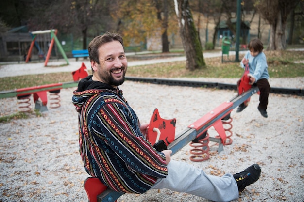 vader en kind hebben samen plezier in het gelukkige familieconcept van de parkspeeltuin