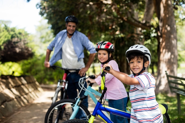 Vader en kinderen die zich met fiets in park bevinden