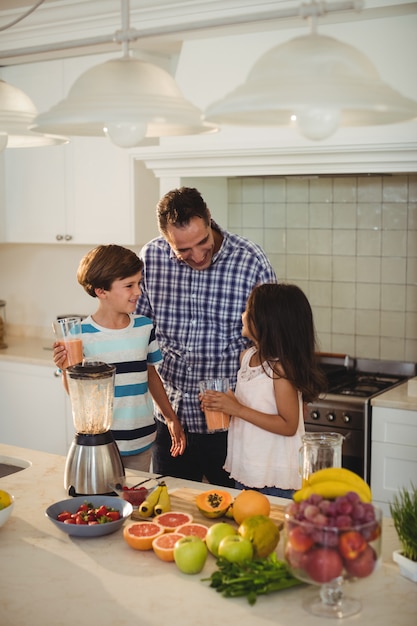 Vader en kinderen houden glas smoothie