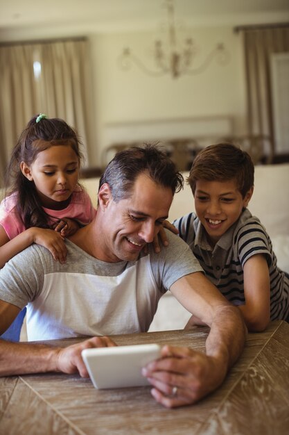 Vader en kinderen met behulp van digitale tablet in de woonkamer