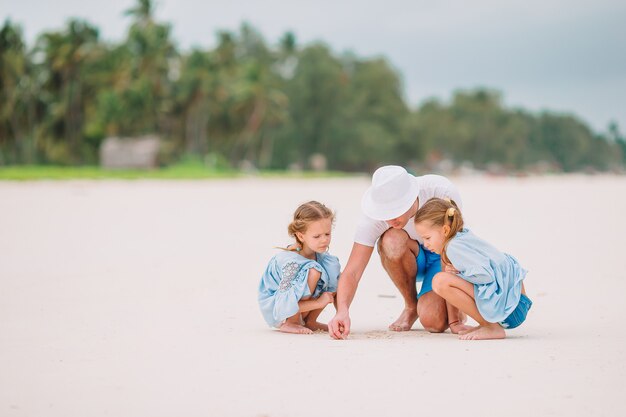 Vader en kinderen op het strand