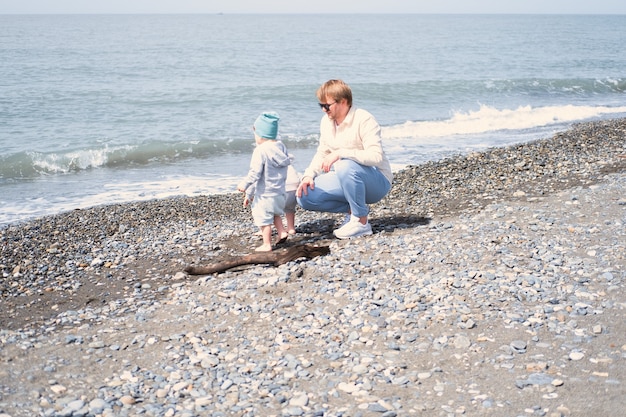 Vader en kinderen twee jongens tweeling spelen met plezier op het strand in de lente of herfst