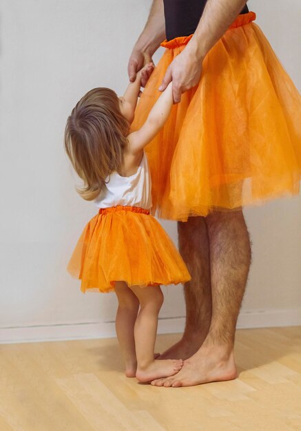 Vader en kleine meid dragen bijpassende ballerinajurken en dansen