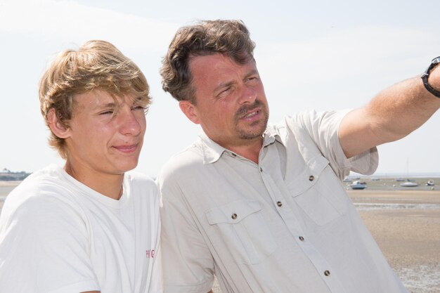 Foto vader en tienerzoon in vakantie tijdens de zomervakantie op strand