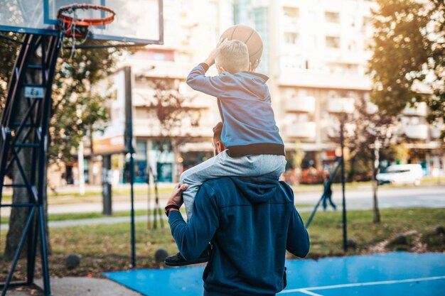 Vader en zijn zoon genieten samen op het basketbalveld.