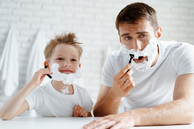 Vader en zijn zoontje scheren samen in de badkamer