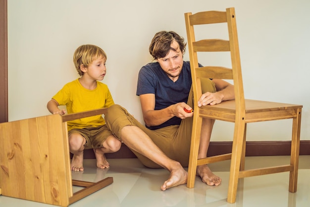 Vader en zoon assembleren meubels Jongen helpt zijn vader thuis Happy Family-concept