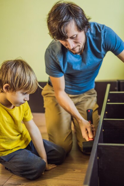 Vader en zoon assembleren meubels Jongen helpt zijn vader thuis Happy Family-concept