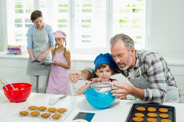 Vader en zoon bereiden van cookies in de keuken