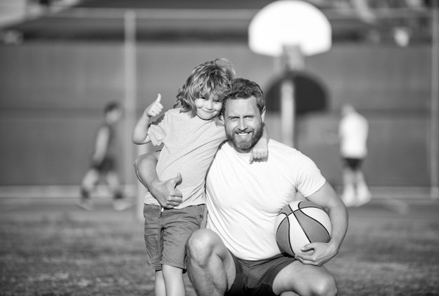 Foto vader en zoon buiten gelukkige vaders dag familieportret vader en kind jongen houden sportbal