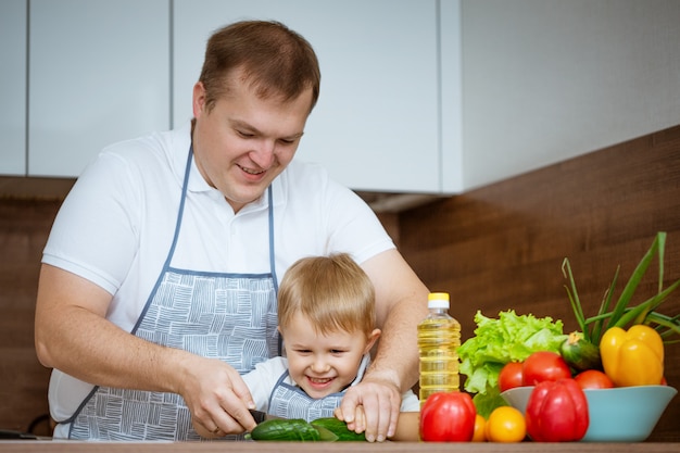 Vader en zoon die een salade in de keuken voorbereiden