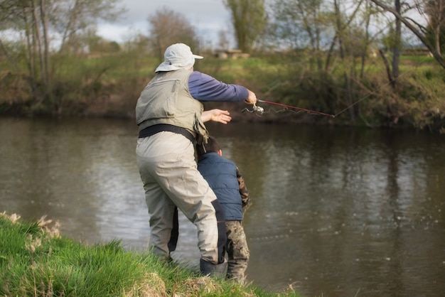 Vader en zoon die op de rivier vissen