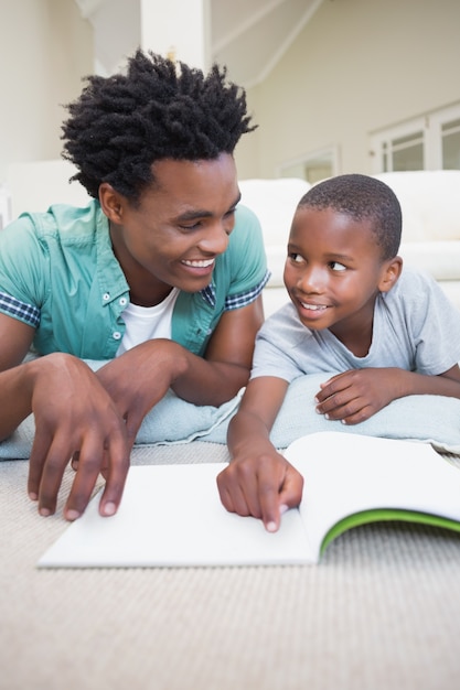 Vader en zoon die op de vloer lezen