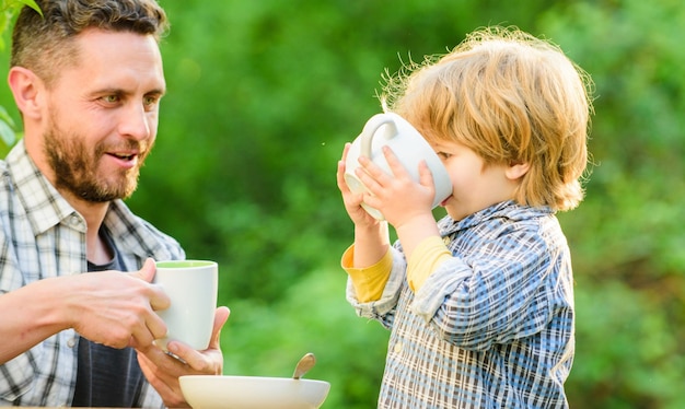 Vader en zoon eten buiten gezond voedsel Familiedag bond kleine jongenskind met vader ze houden van samen eten Weekendontbijt biologische en natuurlijke voeding Samen genieten van tijd