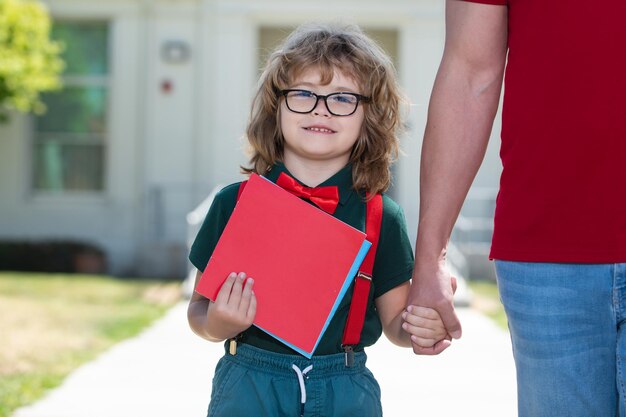 Vader en zoon hand in hand na terugkomst van school