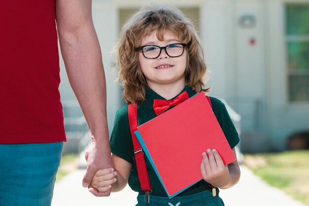 Foto vader en zoon hand in hand na terugkomst van school