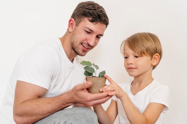 Vader en zoon houden pot met plant en leren over planten