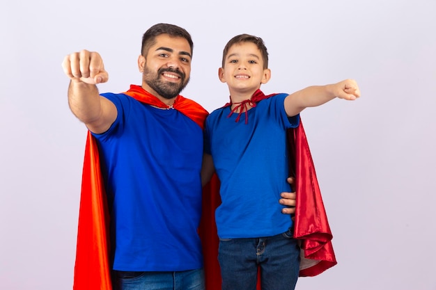 Vader en zoon in rode en blauwe superheldenkostuums Vader en zoon spelen op witte achtergrond in heldenoutfit Vaderdag
