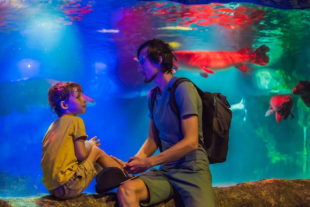 Vader en zoon kijken naar de vissen in het aquarium in oceanarium