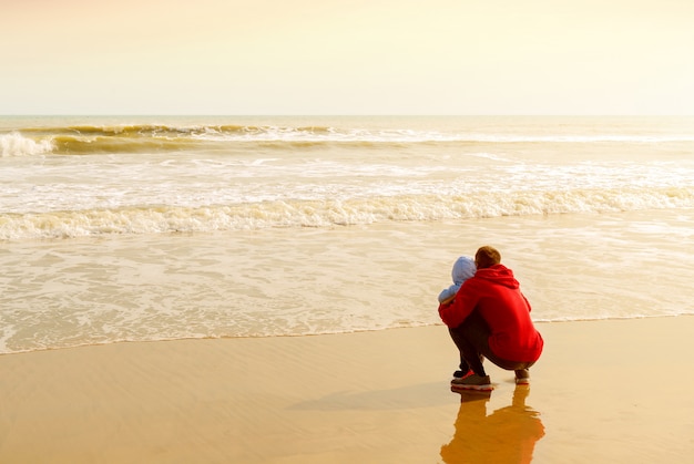 Vader en zoon kijken naar de zee