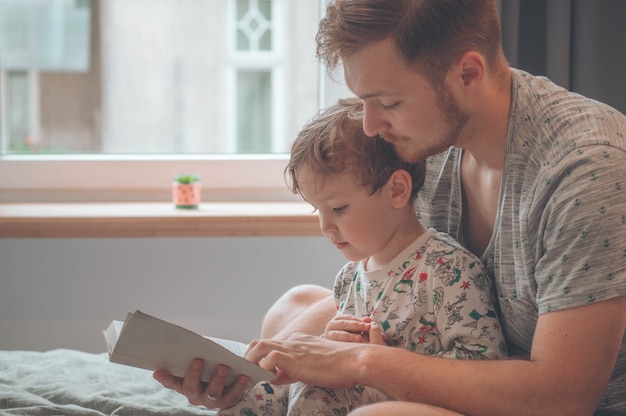 Vader en zoon lazen samen een boek, glimlachend en knuffelend