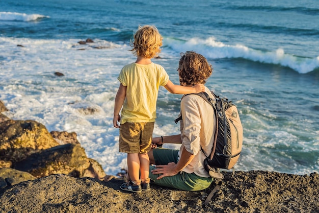 Vader en zoon lopen langs het kosmische strand van Bali... Portretreizen toeristen - vader met kinderen. Positieve menselijke emoties, actieve levensstijl. Gelukkig jong gezin op zee strand