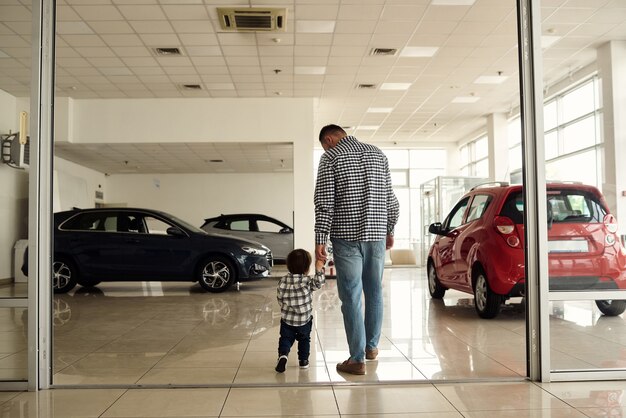 Vader en zoon lopen rond op de grote autoshow en overwegen nieuwe automodellen.