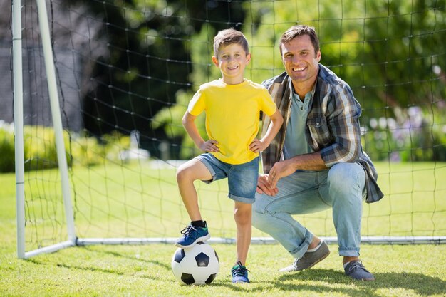 Vader en zoon met voetbal in het park op een zonnige dag