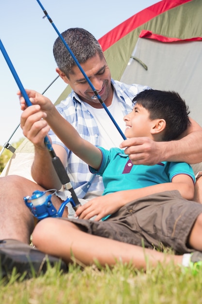 Vader en zoon naast hun tent op een zonnige dag