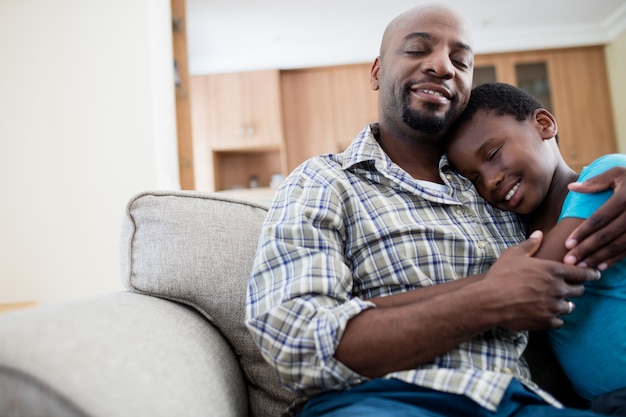 Vader en zoon omhelzen elkaar in de woonkamer