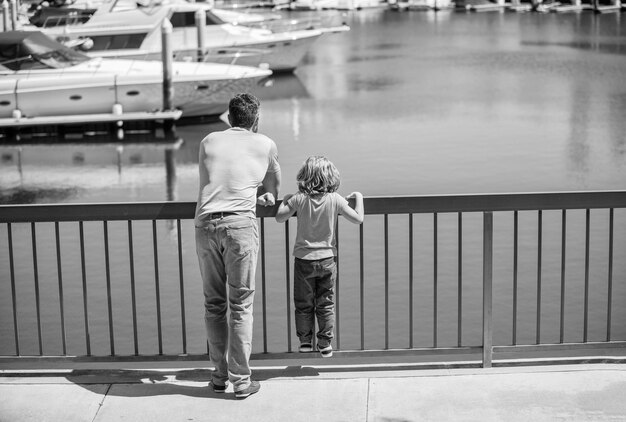 Vader en zoon ontspannen kijken naar jachten in het familieweekend in de haven