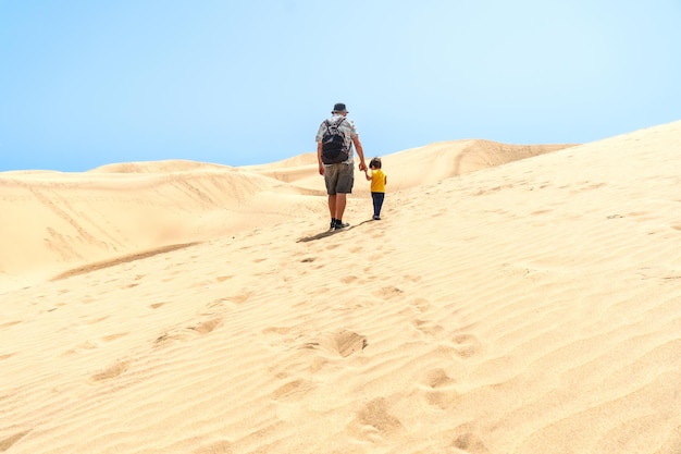 Vader en zoon op vakantie lachen in de duinen van Maspalomas Gran Canaria Canarische eilanden