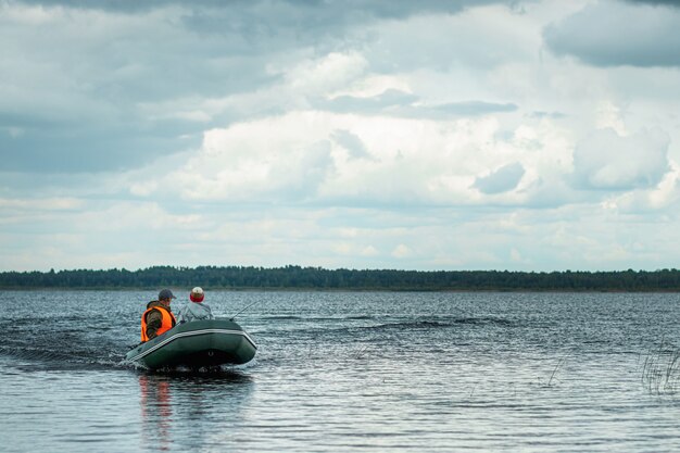 Vader en zoon rijden een motorboot op het meer.