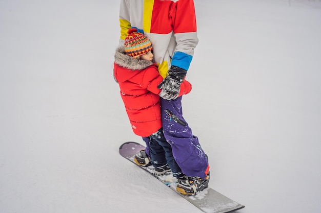 Vader en zoon rijden op dezelfde snowboard en breken veiligheidsmaatregelen