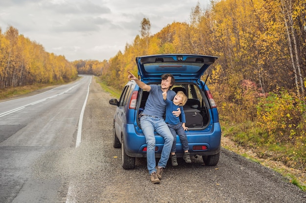 Vader en zoon rusten aan de kant van de weg tijdens een roadtrip. Road trip met kinderen concept.