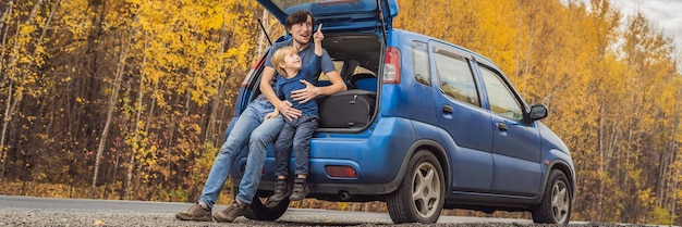 Vader en zoon rusten aan de kant van de weg tijdens een roadtrip. Road trip met kinderen concept.