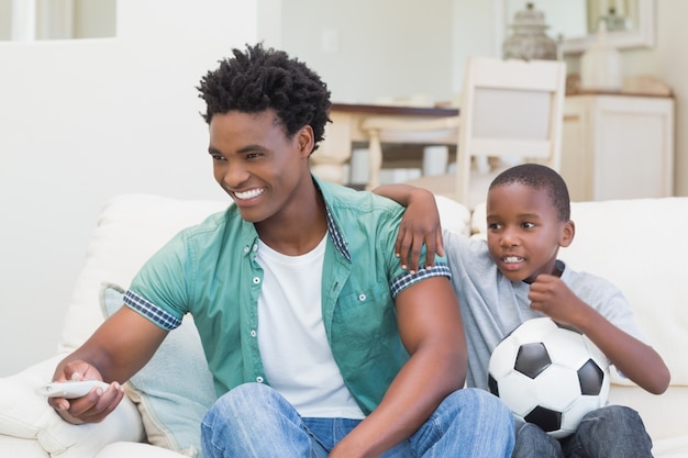 Vader en zoon samen tv kijken op de bank