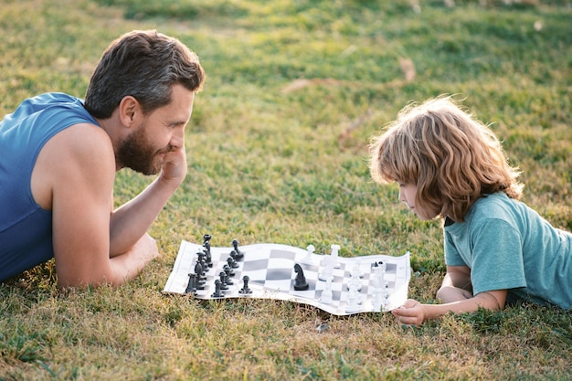 Vader en zoon schaken samen buiten tijd doorbrengen