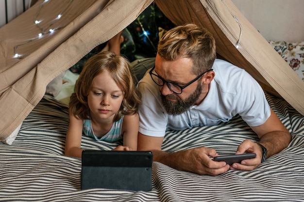 Vader en zoon spelen thuis in een tipi-tent