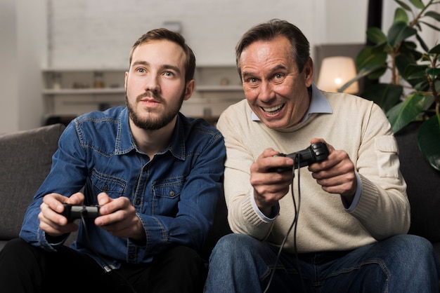 Vader en zoon spelen van videogames in woonkamer