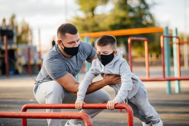 Vader en zoon sporten in maskers op het sportveld