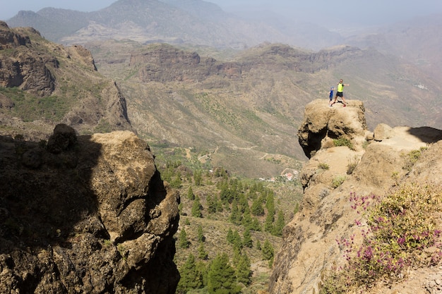 Vader en zoon staan op de rotstop op een zonnige dag in Roque Nublo Gran Canaria Wandelaars op de berg