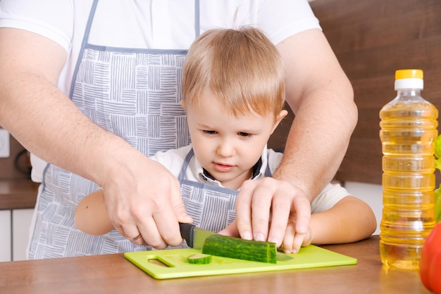 Vader en zoon thuis staan samen in de keuken man glimlachend