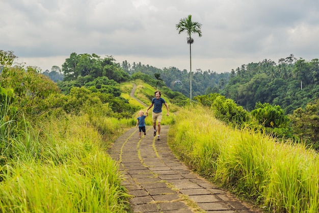 Vader en zoon toeristen in Campuhan Ridge Walk, Scenic Green Valley in Ubud Bali. Reizen met kinderen concept.