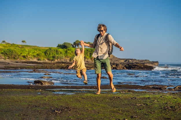 Vader en zoon toeristen op de achtergrond van Tanah Lot - Tempel in de Oceaan. Bali, Indonesië. Reizen met kinderen concept