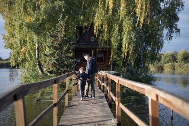 Vader en zoon toeristen op Oude brug Aantrekkelijkheid Lange extreme houten brug over de rivier