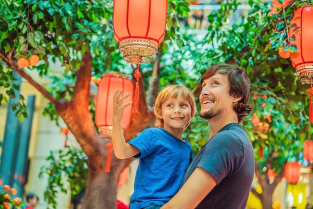 Vader en zoon vieren Chinees Nieuwjaar, kijken naar Chinese rode lantaarns